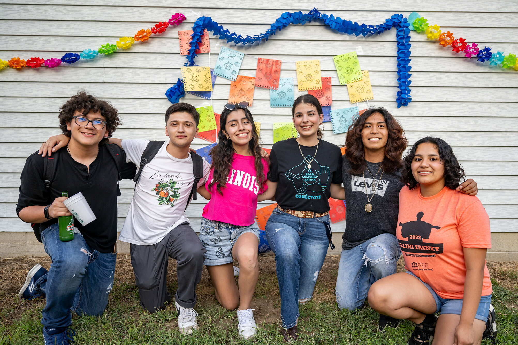 group of latino studies students pose in front of colorful banner