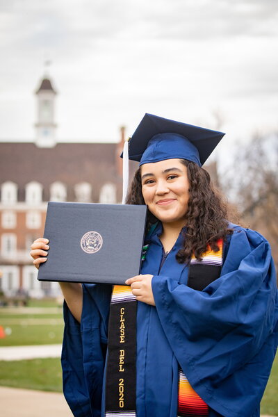 Graduating student holds up diploma
