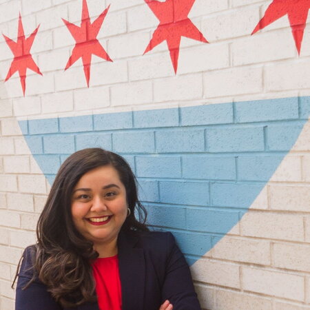 Nancy Cambron Perez Headshot in front of Flag of Chicago Mural 